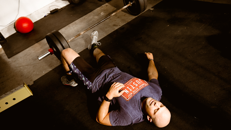 Dusty rests on floor next to weights 